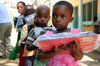 512px-US_Navy_091102-N-2420K-127_A_child_holds_a_packet_of_school_supplies_at_the_Tongoni_Primary_School_in_Tanga,_Tanzania-1
